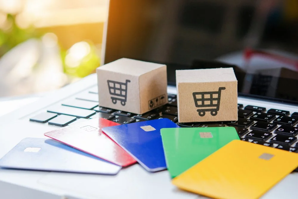  Credit card and cardboard box with a shopping cart logo on laptop keyboard 