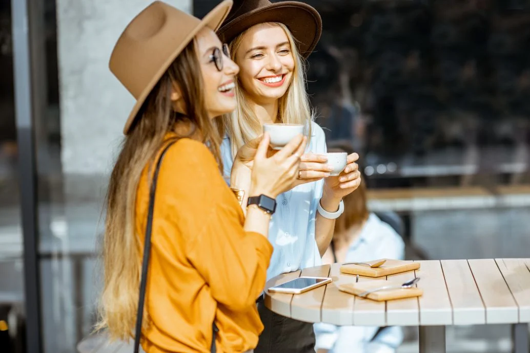  Girlfriends spending time together on a cafe terrace 